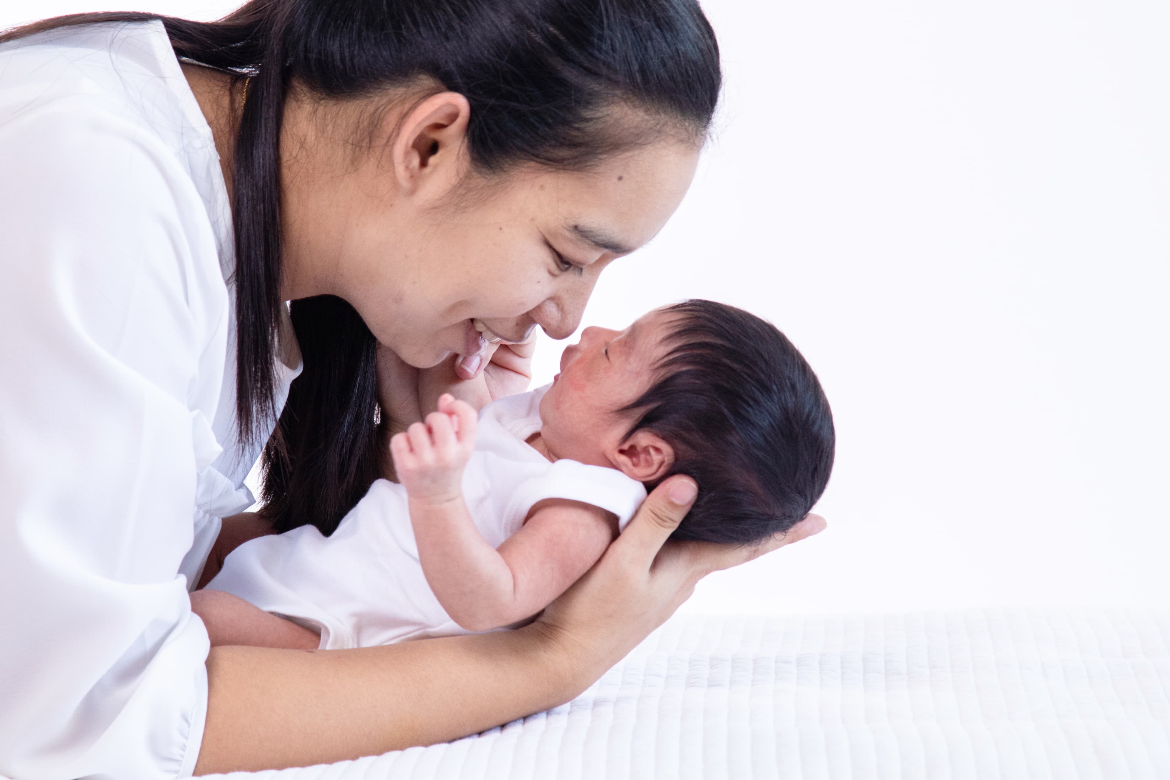 Mother kissing her newborn baby after fertility treatment at Angel Fertility Clinic